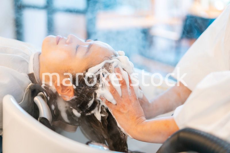 ヘアサロンでスチームトリートメントを受ける女性