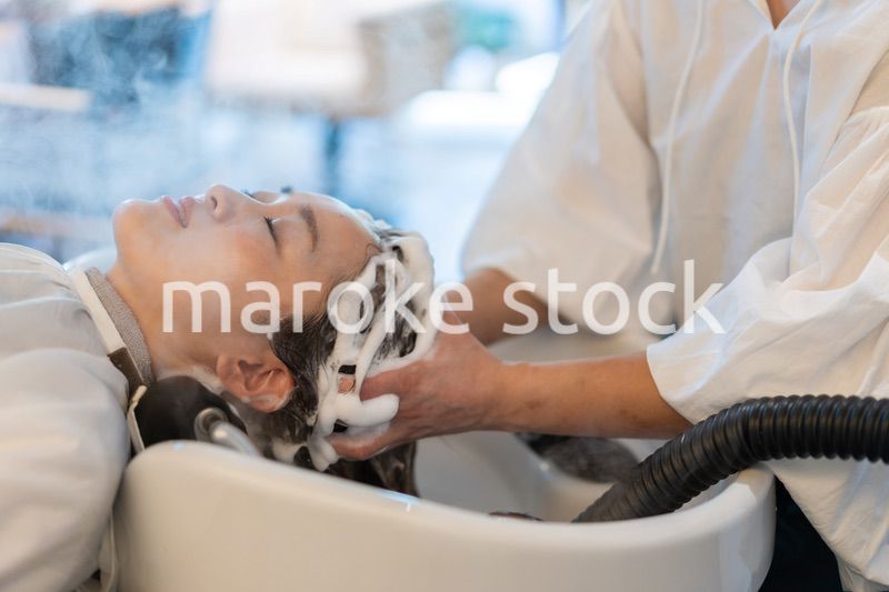 ヘアサロンでスチームトリートメントを受ける女性