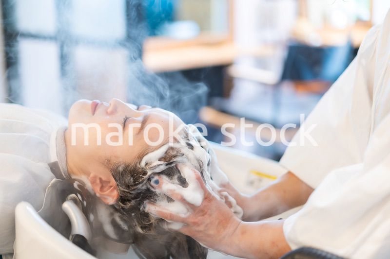 ヘアサロンでスチームトリートメントを受ける女性