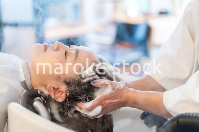 ヘアサロンでスチームトリートメントを受ける女性