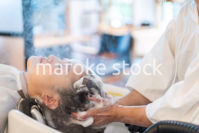 ヘアサロンでスチームトリートメントを受ける女性