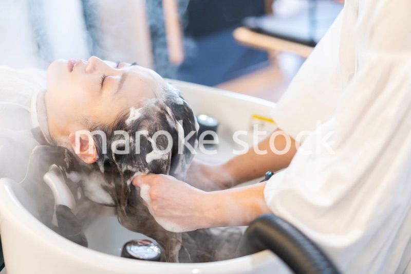 ヘアサロンでスチームトリートメントを受ける女性