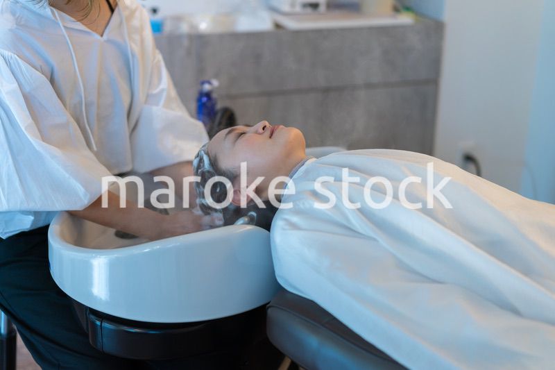 ヘアサロンでスチームトリートメントを受ける女性