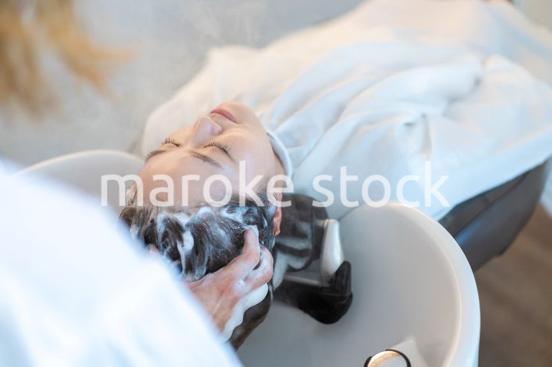 ヘアサロンでスチームトリートメントを受ける女性
