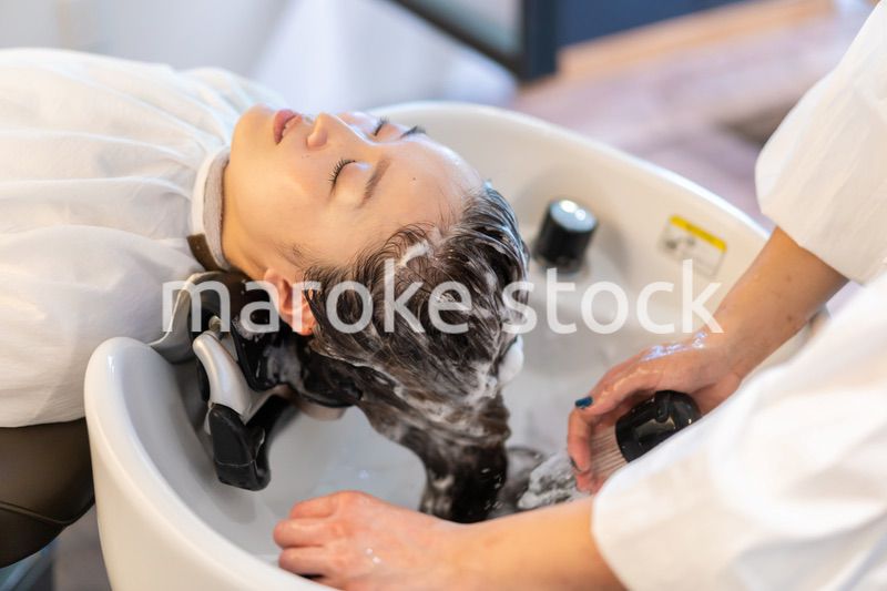 ヘアサロンでスチームトリートメントを受ける女性