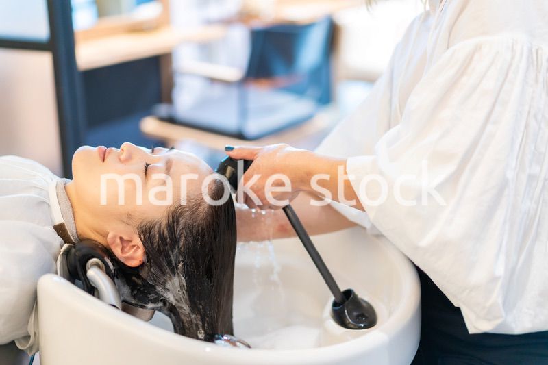 お客様にシャンプーをする美容師