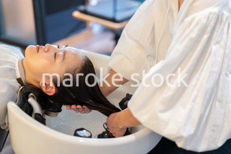 お客様にシャンプーをする美容師