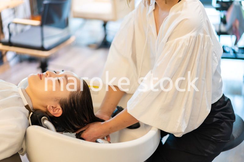 お客様にシャンプーをする美容師