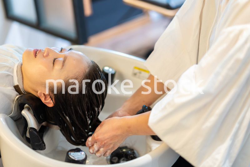 お客様にシャンプーをする美容師