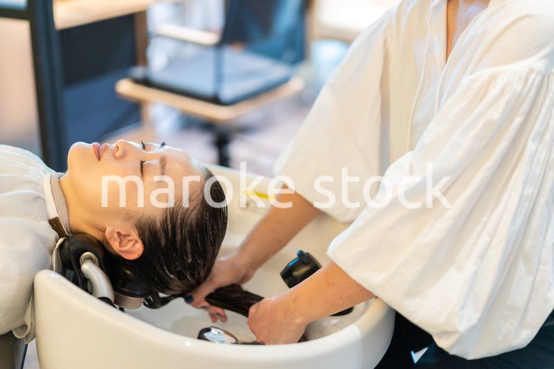 お客様にシャンプーをする美容師