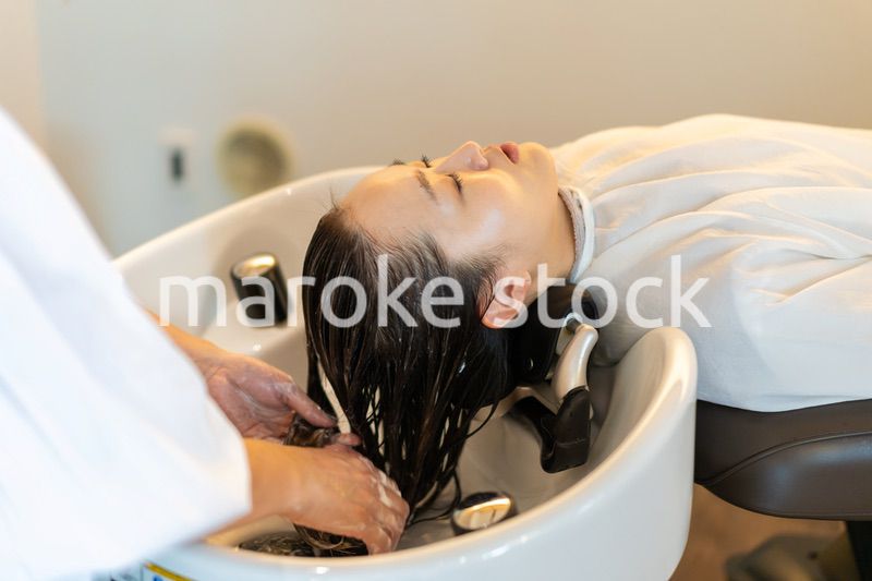 お客様にシャンプーをする美容師