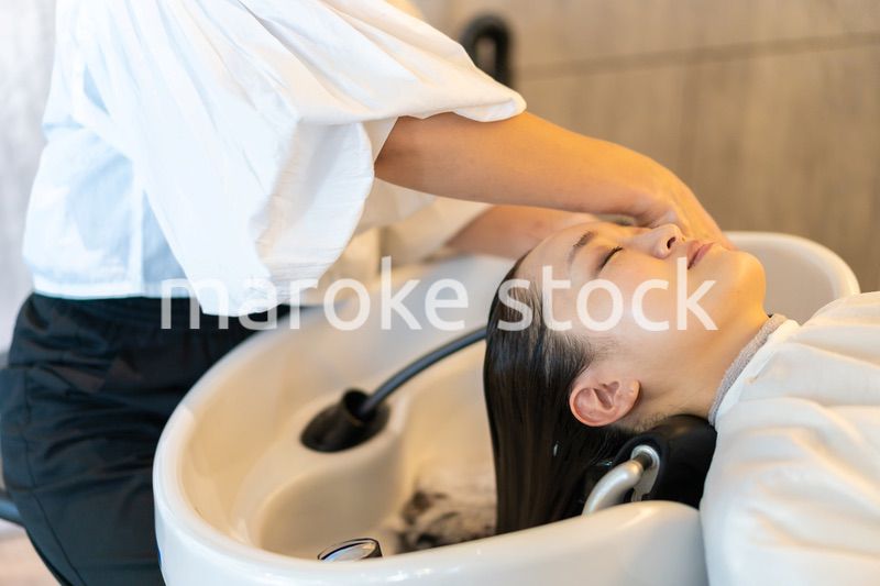 お客様にシャンプーをする美容師