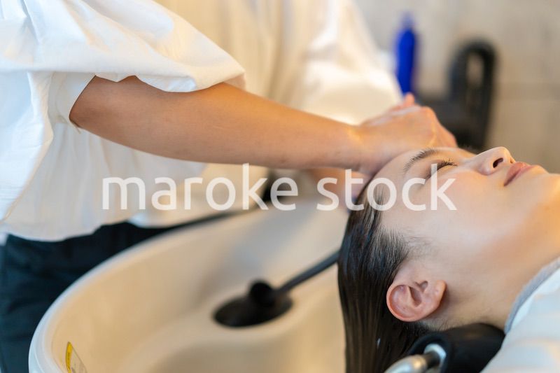 お客様にシャンプーをする美容師