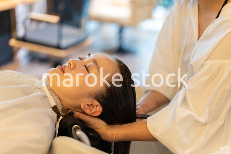 お客様にシャンプーをする美容師