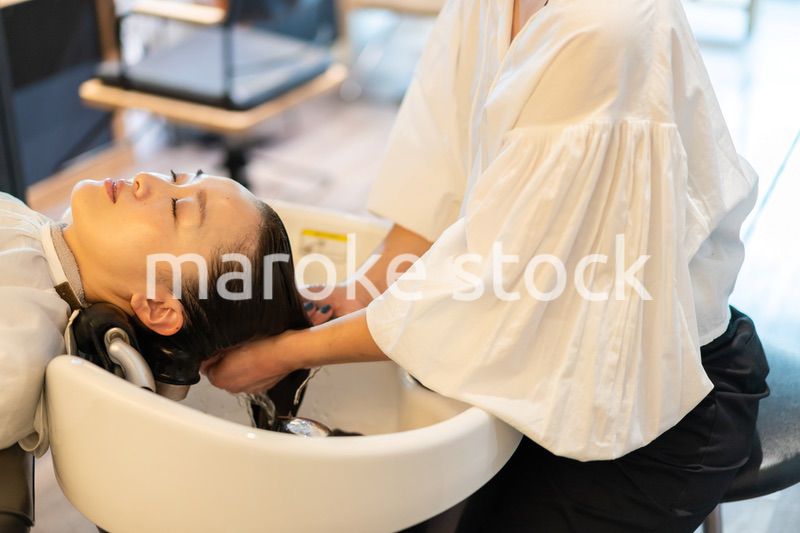 お客様にシャンプーをする美容師