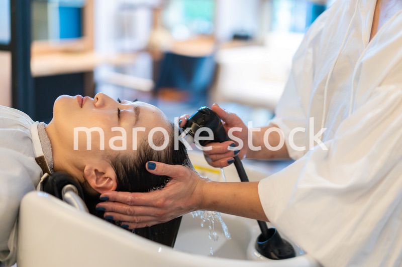 お客様にシャンプーをする美容師