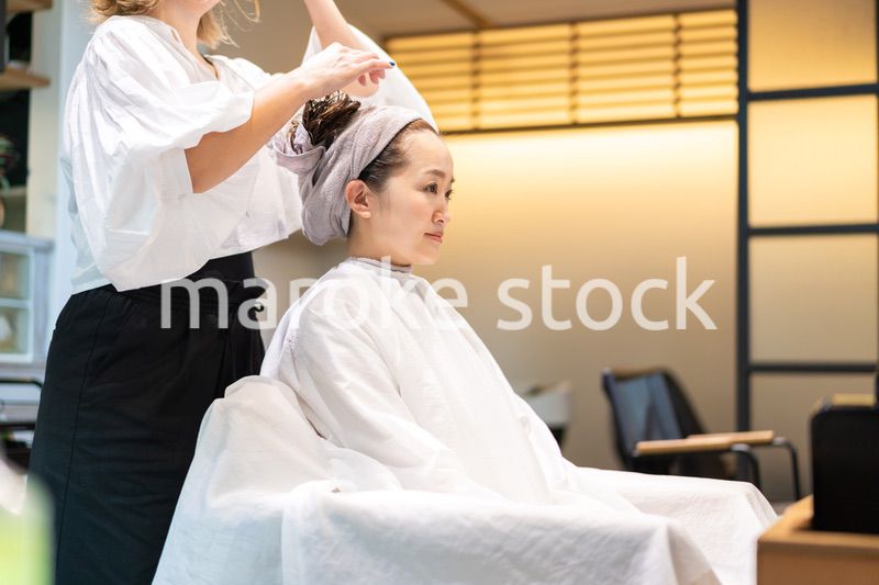 シャンプー台でシャンプーをする美容師