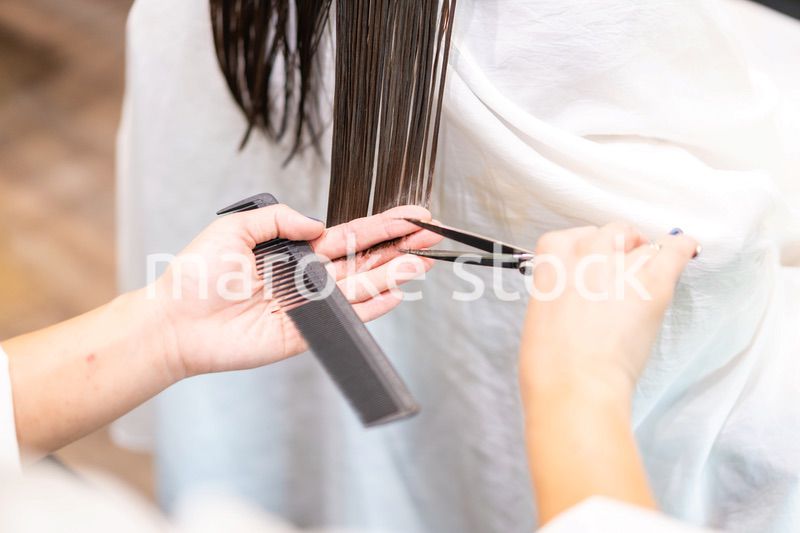 女性のヘアカットをする美容師