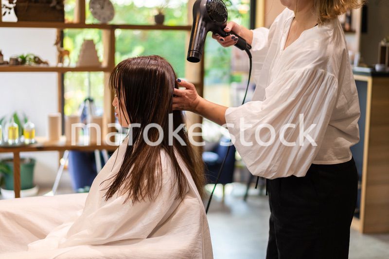 美容室で髪をカットする女性