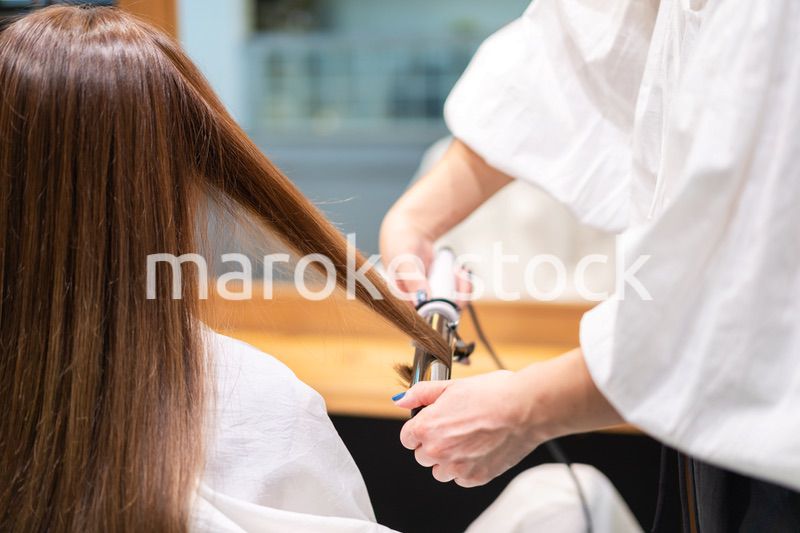 ヘアアイロンを使う美容師