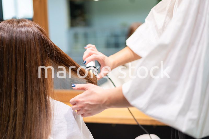 ヘアアイロンを使う美容師