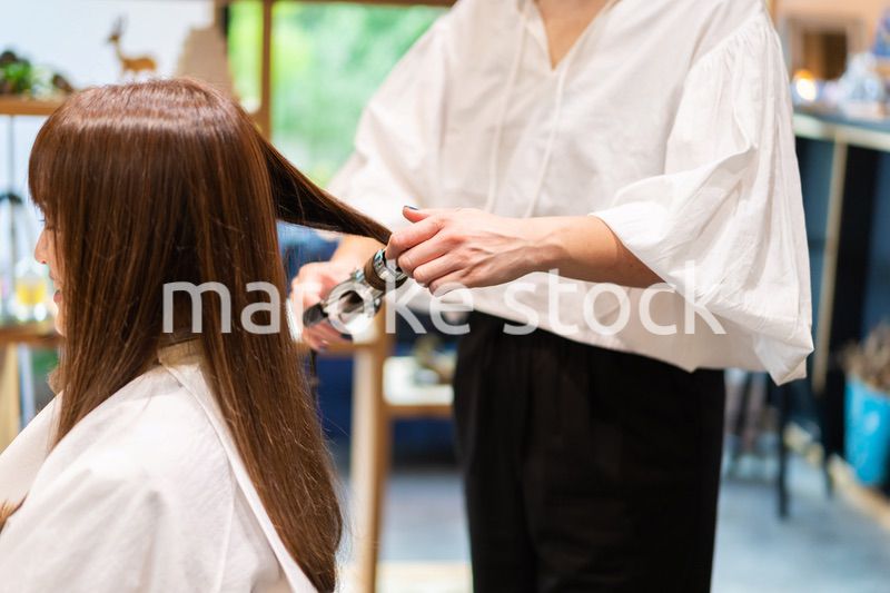 ヘアアイロンを使う美容師