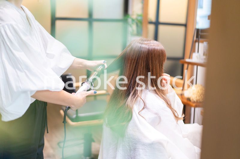 ヘアアイロンを使う美容師