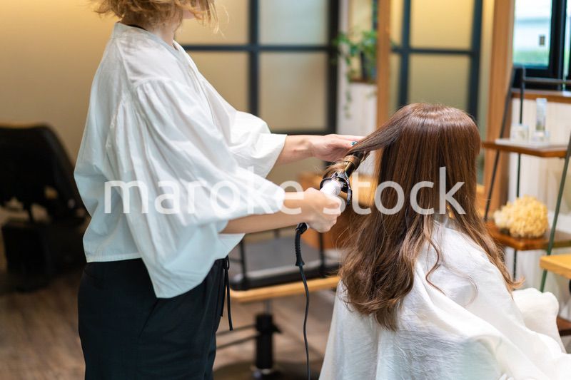 ヘアアイロンを使う美容師