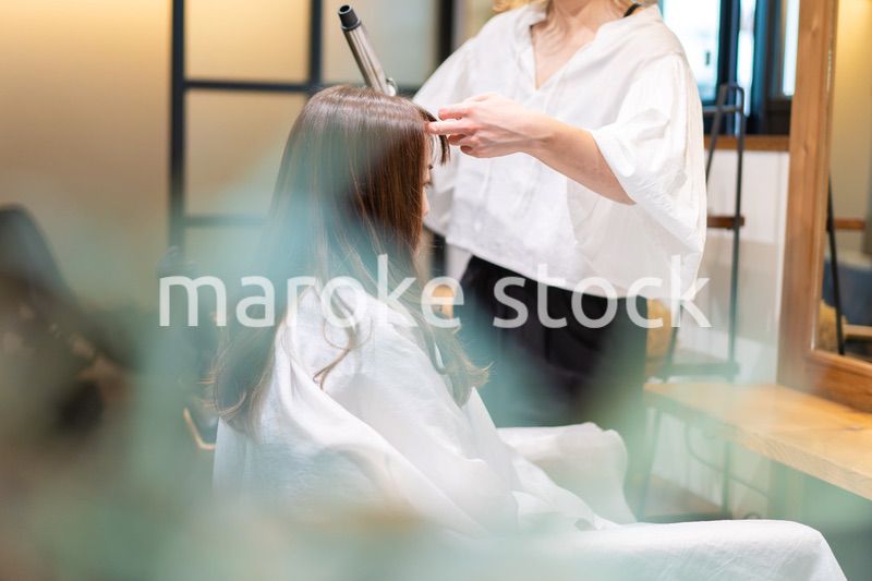 ヘアアイロンを使う美容師