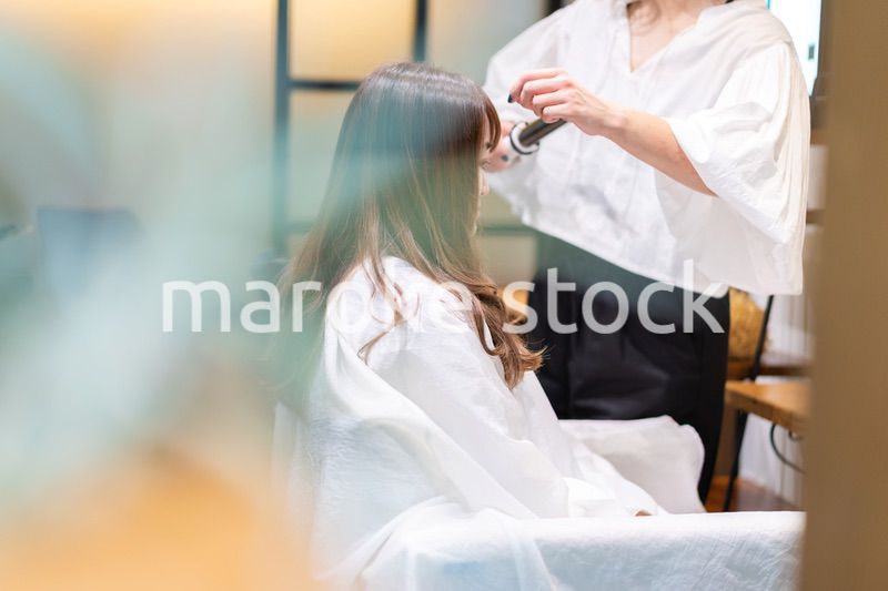 ヘアアイロンを使う美容師