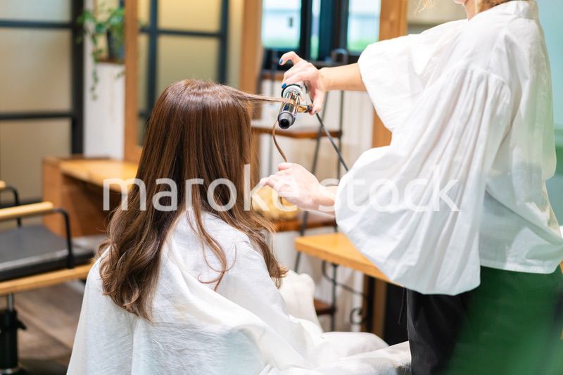 ヘアアイロンを使う美容師