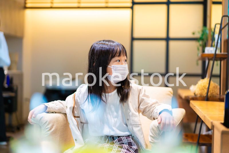 マスクをして美容院の椅子に座る子供