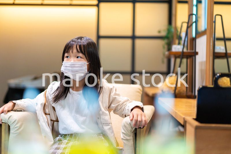 マスクをして美容院の椅子に座る子供